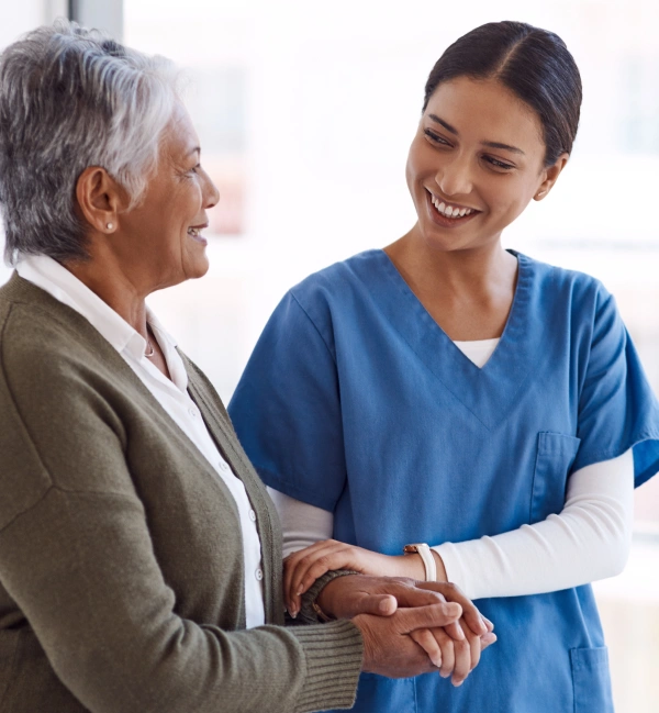 Oracle RMS website section for healthcare key professions showing a smiling nurse in blue scrubs comfortingly holding an elderly patient's hand next to an industry list.